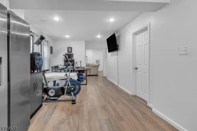a view of a kitchen with dining area a refrigerator and wooden floor