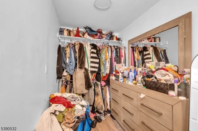 a view of walk in closet with clothes and shoes