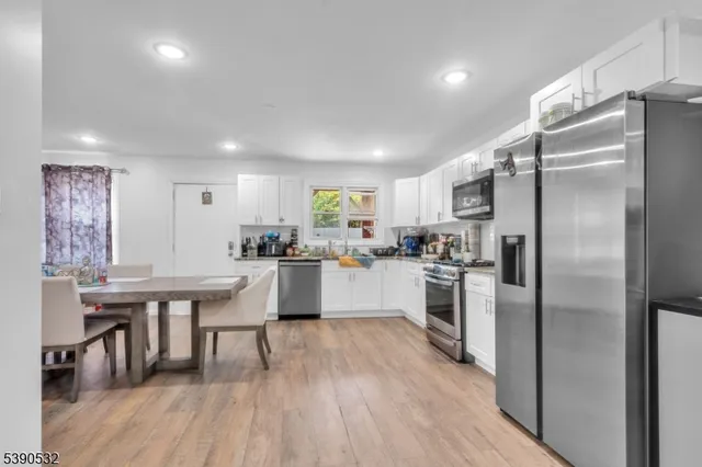 a kitchen with kitchen island white cabinets and stainless steel appliances