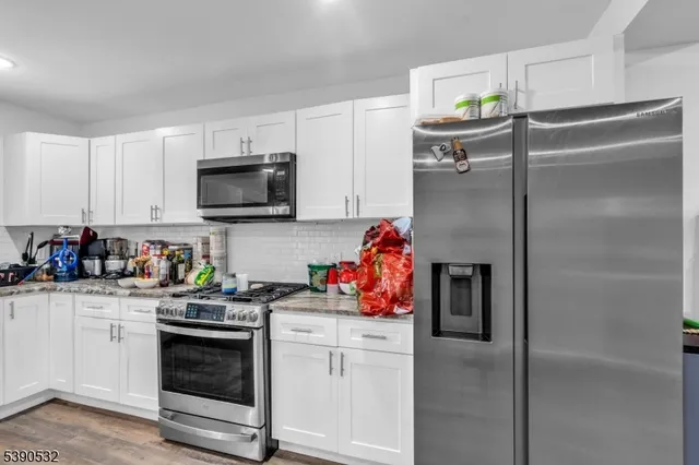 a kitchen with stainless steel appliances granite countertop a refrigerator sink and stove top oven