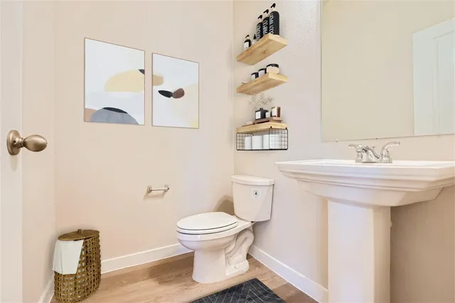 a bathroom with a sink toilet and mirror