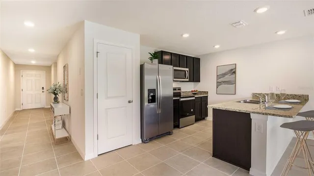 a kitchen with stainless steel appliances granite countertop a refrigerator and a sink