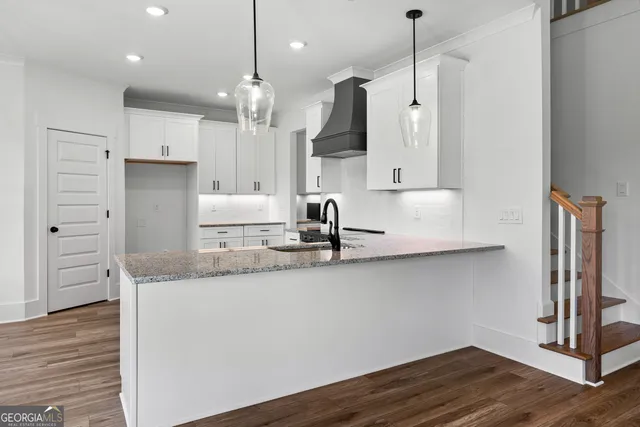 a kitchen with kitchen island granite countertop a sink a counter space appliances and cabinets