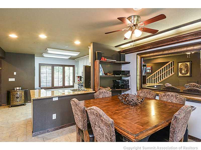 1944 Soda Ridge Road, Unit 1229 Keystone, CO 80435 - Photo 5 of 17 a room with stainless steel appliances kitchen island granite countertop a refrigerator a stove a dining table and chairs with wooden floor