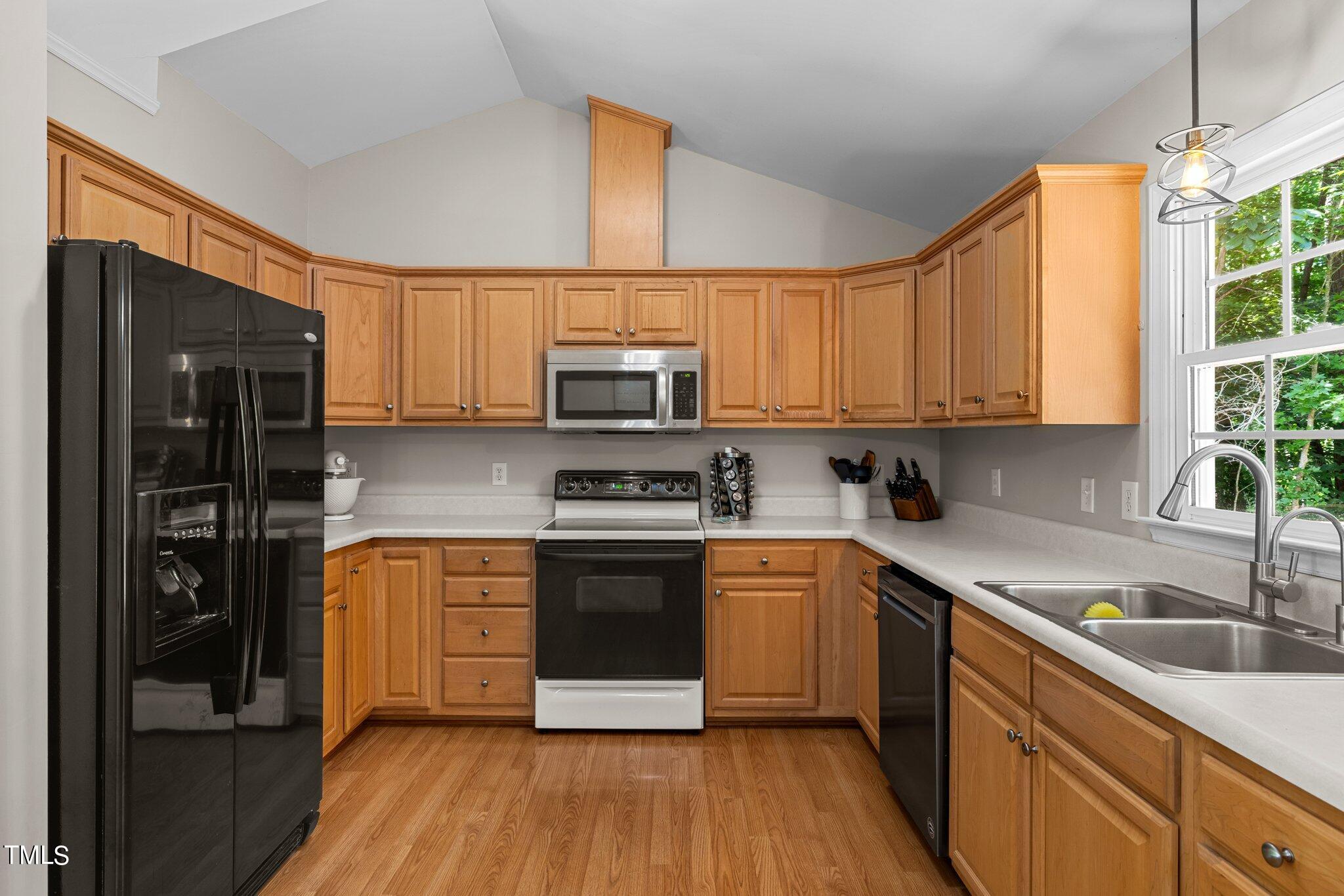 7031 Calais Drive Durham, NC 27712 - Photo 13 of 48 a kitchen with stainless steel appliances granite countertop a stove a sink and a refrigerator
