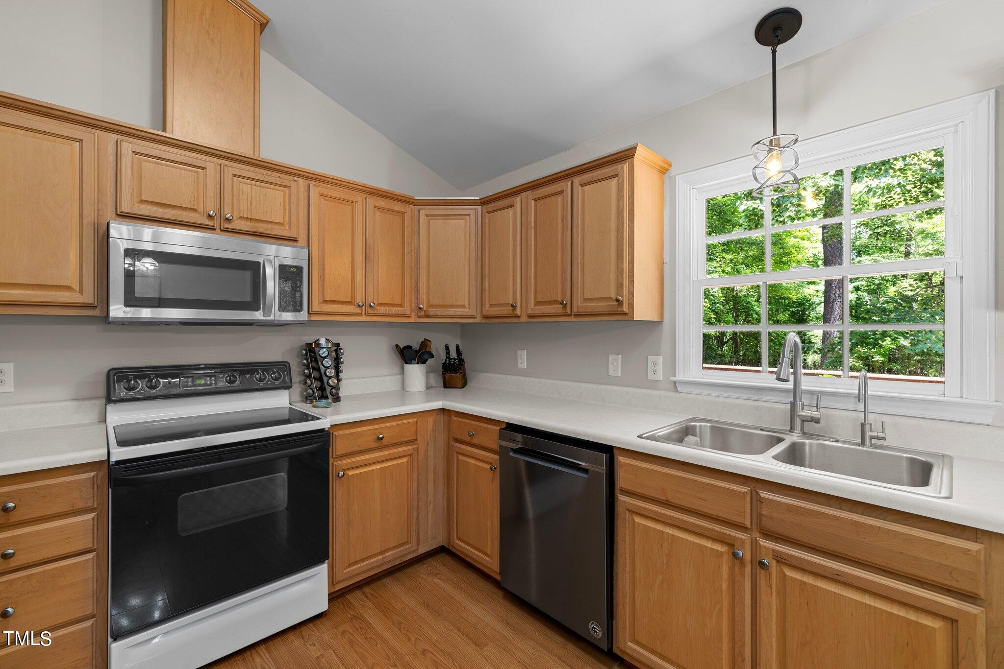 7031 Calais Drive Durham, NC 27712 - Photo 14 of 48 a kitchen with a sink stove top oven and microwave