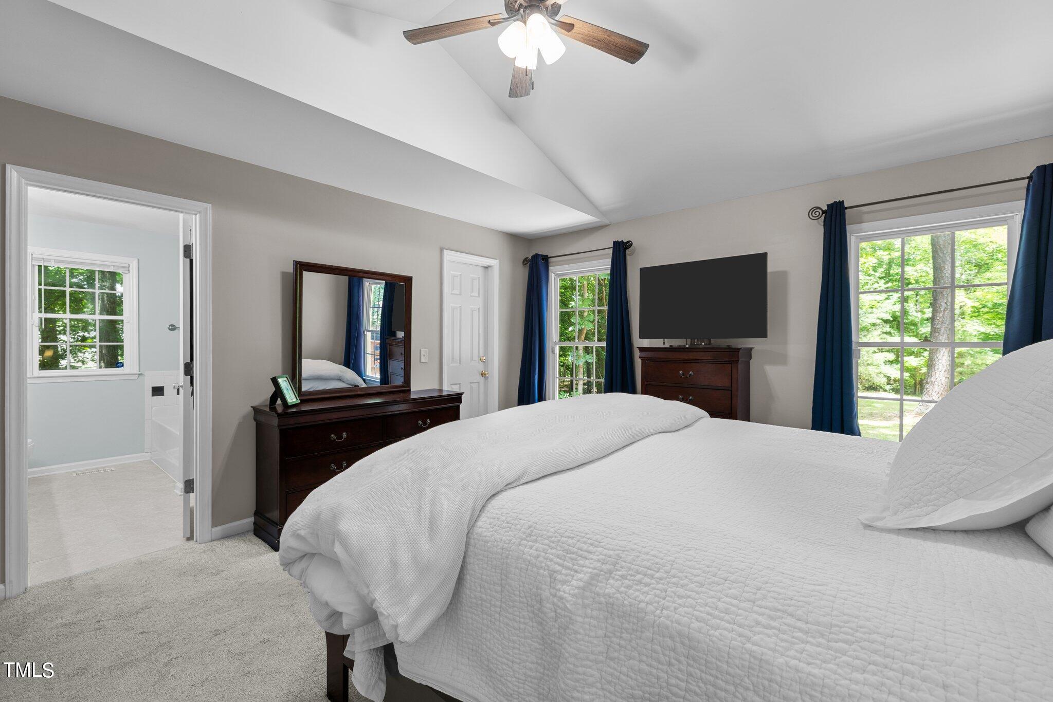 7031 Calais Drive Durham, NC 27712 - Photo 19 of 48 a bedroom with a large bed and a flat tv screen