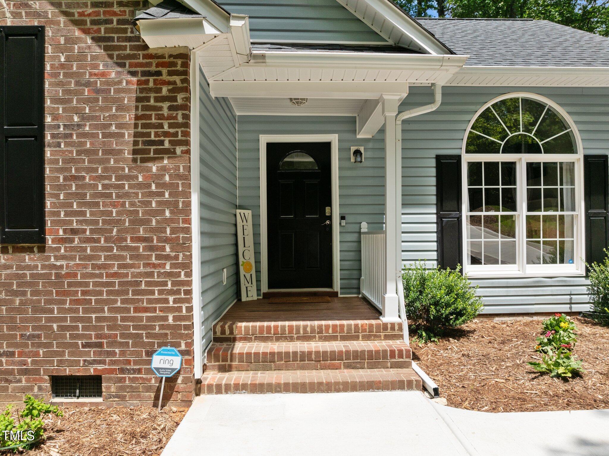7031 Calais Drive Durham, NC 27712 - Photo 3 of 48 a front view of a house with a garden