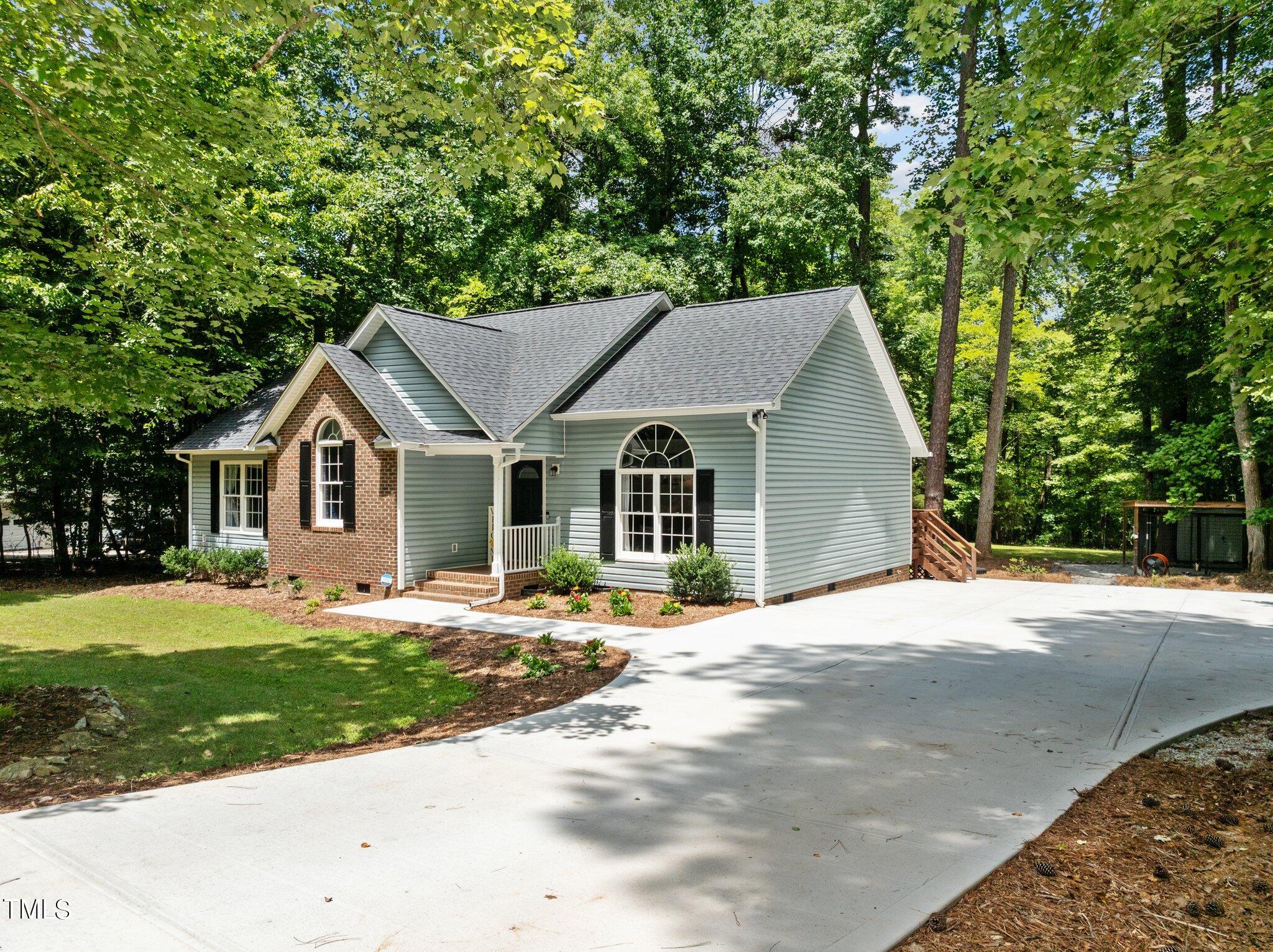 7031 Calais Drive Durham, NC 27712 - Photo 42 of 48 a front view of a house with a yard and trees