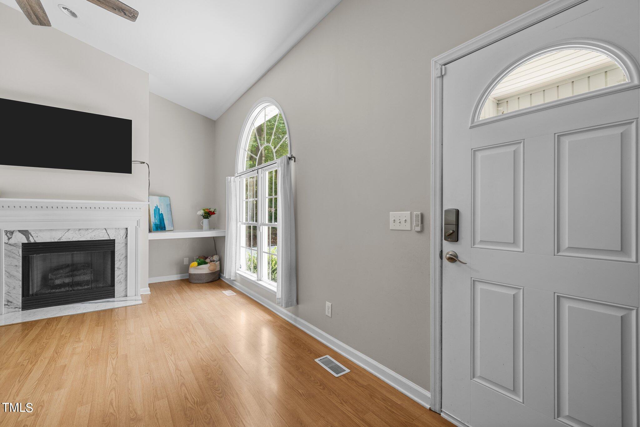 7031 Calais Drive Durham, NC 27712 - Photo 10 of 48 a living room with a fireplace and a flat screen tv