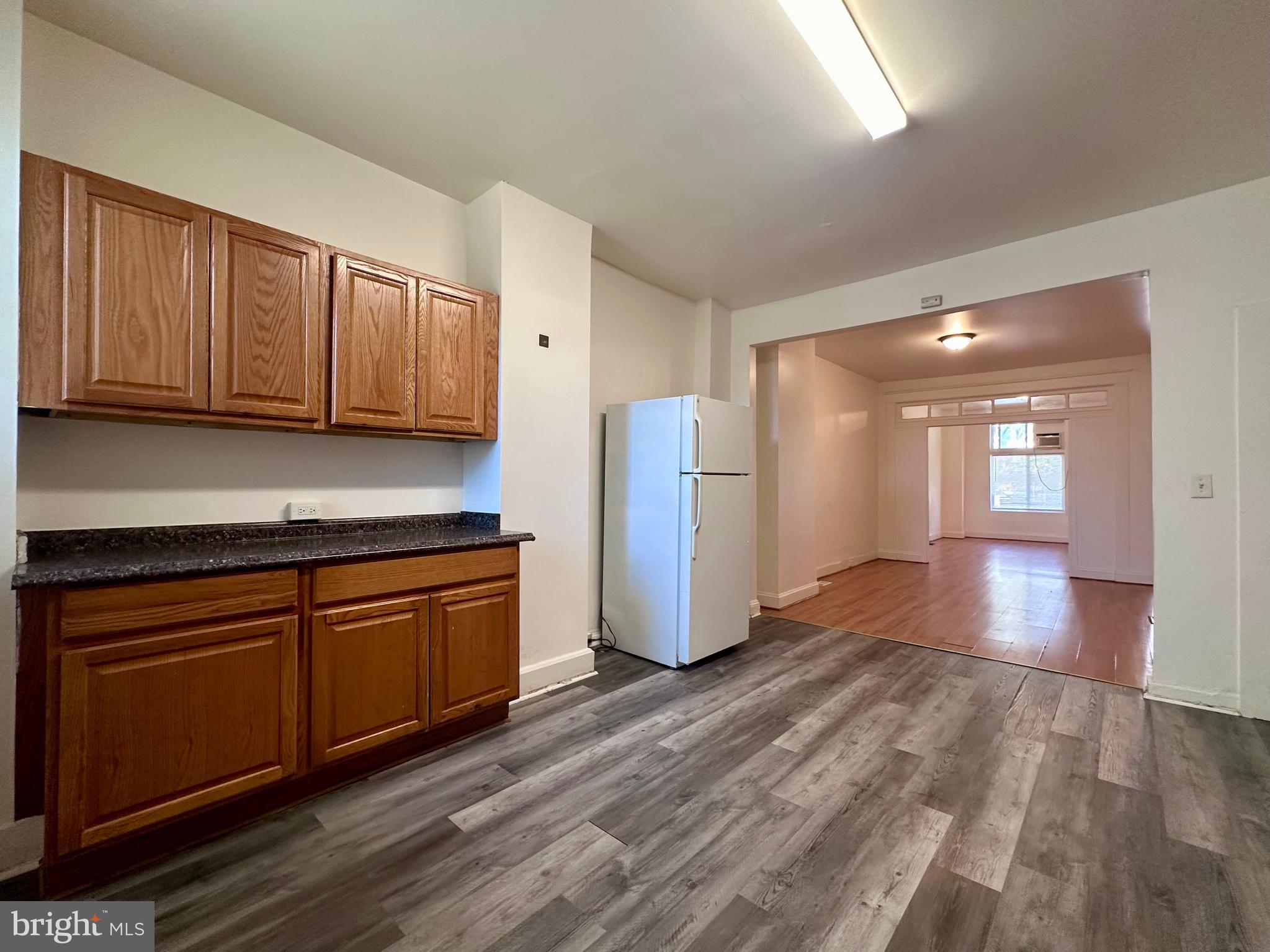 2770 The Alameda Baltimore, MD 21218 - Photo 21 of 33 a kitchen with stainless steel appliances granite countertop a refrigerator a sink dishwasher and wooden cabinets with wooden floor