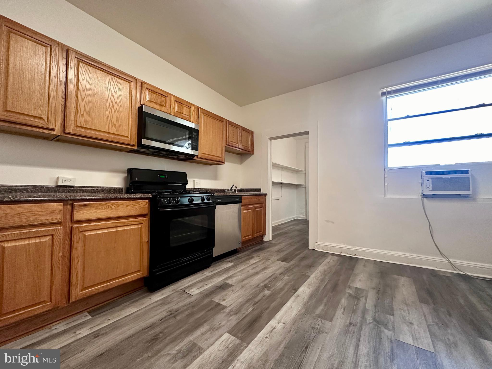 2770 The Alameda Baltimore, MD 21218 - Photo 5 of 33 a kitchen with granite countertop wooden floors and stainless steel appliances