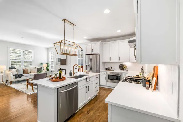 a kitchen with a sink stove and wooden floor