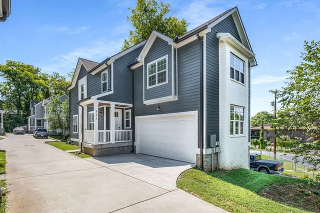 a front view of a house with a yard and trees