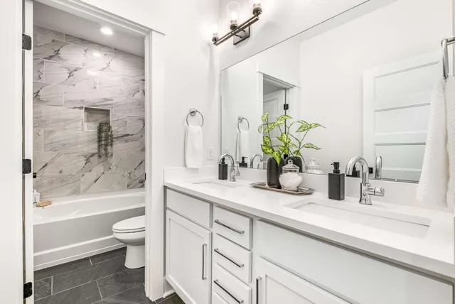 a bathroom with a granite countertop sink a toilet and a bathtub