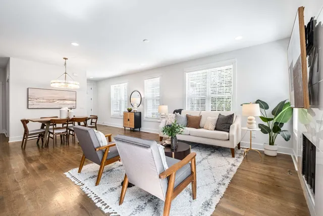 a living room with furniture a dining table and a large window