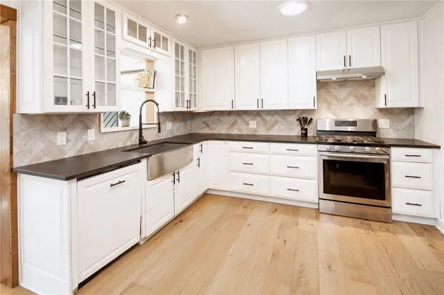 a kitchen with granite countertop a stove sink and cabinets