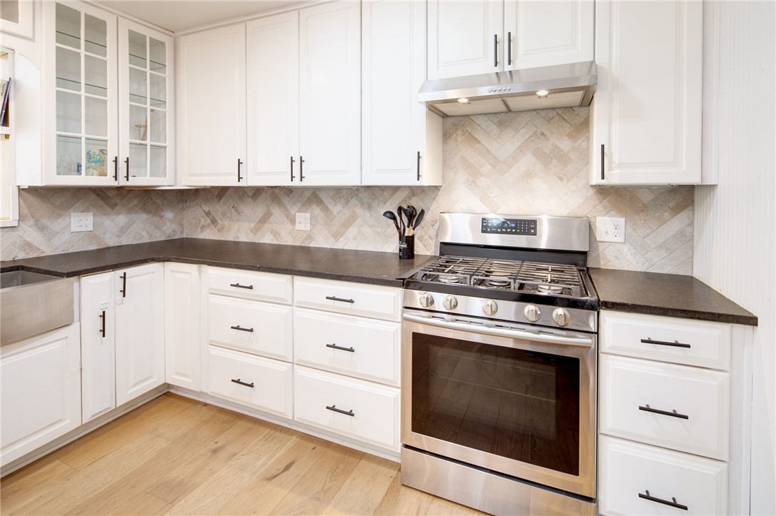 833 Enfield Street Bryan, TX 77802 - Photo 13 of 33 a kitchen with granite countertop white cabinets and stainless steel appliances