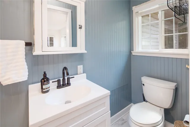 a bathroom with a toilet sink and mirror