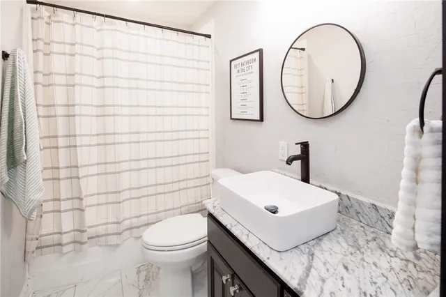 a bathroom with a sink a toilet and a mirror