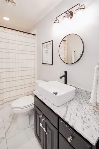 a bathroom with a sink a toilet and a mirror