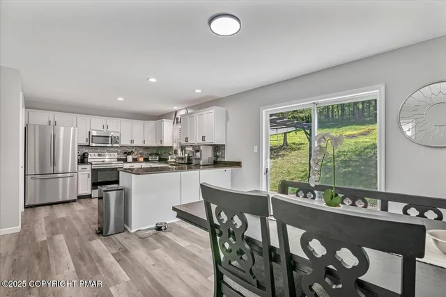 a kitchen with stainless steel appliances granite countertop a refrigerator a stove a sink and a granite counter tops with white cabinets