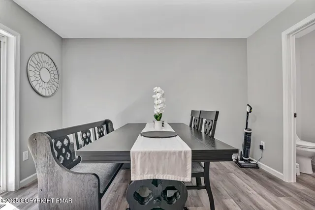 a kitchen with stainless steel appliances granite countertop a refrigerator a stove a sink and white cabinets with wooden floor