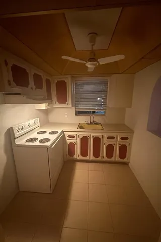 a utility room with a stove top oven and cabinets