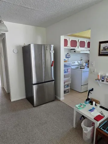 a kitchen with a refrigerator and a table in it