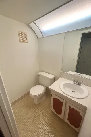 a bathroom with a sink a toilet and a mirror