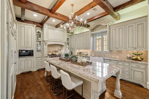 a kitchen with center island white cabinets and stainless steel appliances