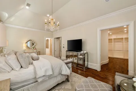 a bedroom with bed tv and chair