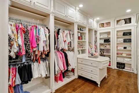 a view of walk in closet with clothes and shoes