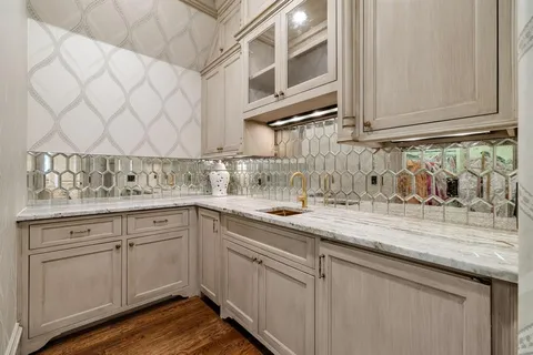 a kitchen with stainless steel appliances granite countertop white cabinets and a sink