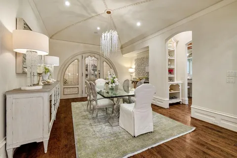 a living room with couches chairs and kitchen view with wooden floor