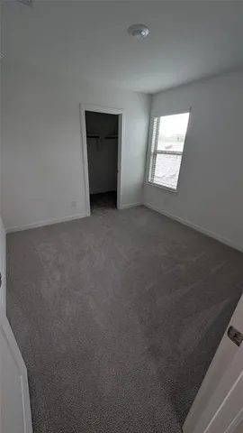 an empty room with windows and ceiling fan