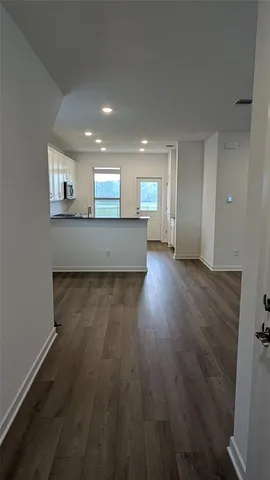 a view of a kitchen with wooden floor and a window