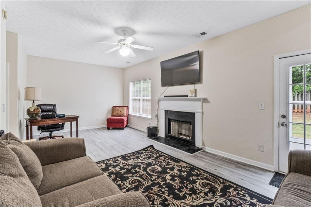 675 Michael Circle Monroe, GA 30655 - Photo 16 of 34 a living room with furniture a flat screen tv and a fireplace