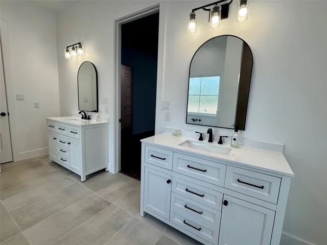 a bathroom with a double vanity sink and mirror