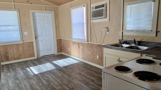 a kitchen with a wooden floor and cabinets