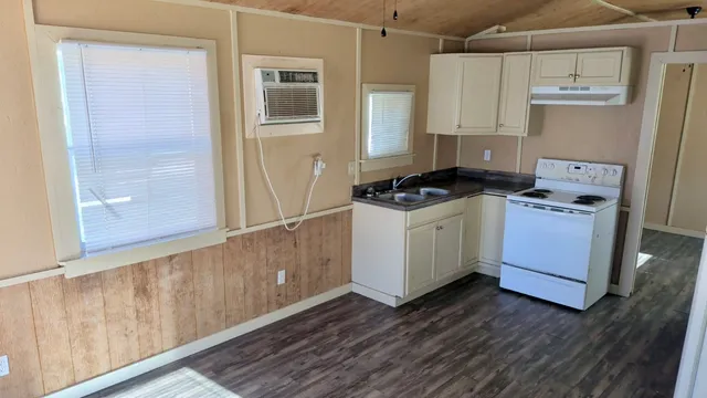 a kitchen with wooden floor and white stove
