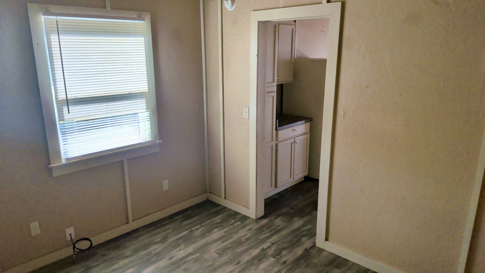 401 North Clegg Street Trinity, TX 75862 - Photo 10 of 15 a view of an empty room with wooden floor and a window