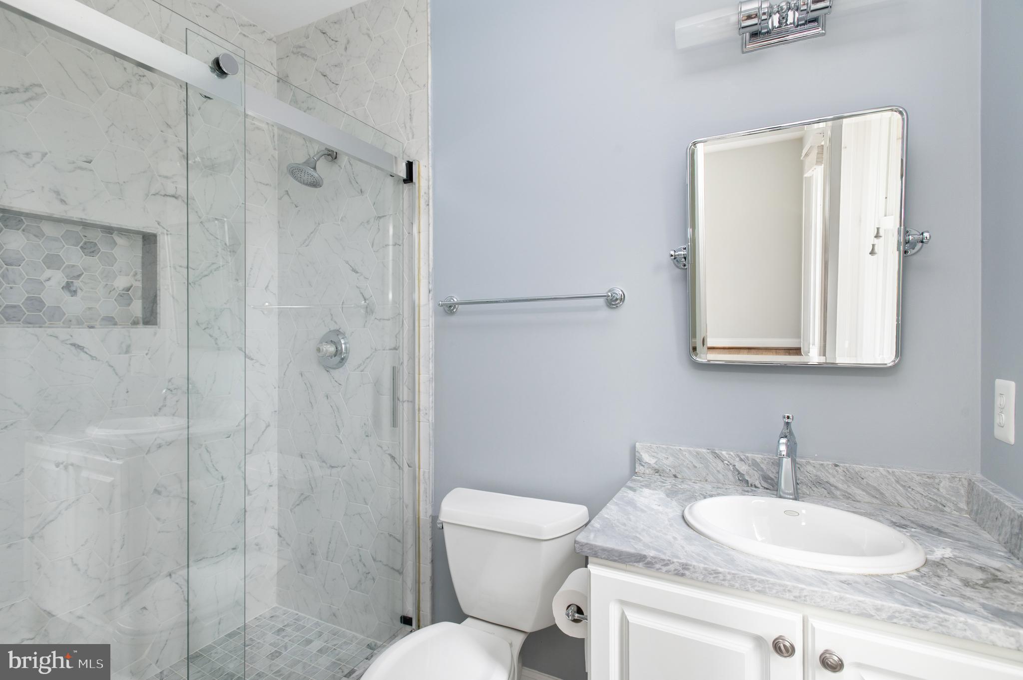 5400 Mohican Road Bethesda, MD 20816 - Photo 20 of 47 a bathroom with a granite countertop toilet a sink and a mirror