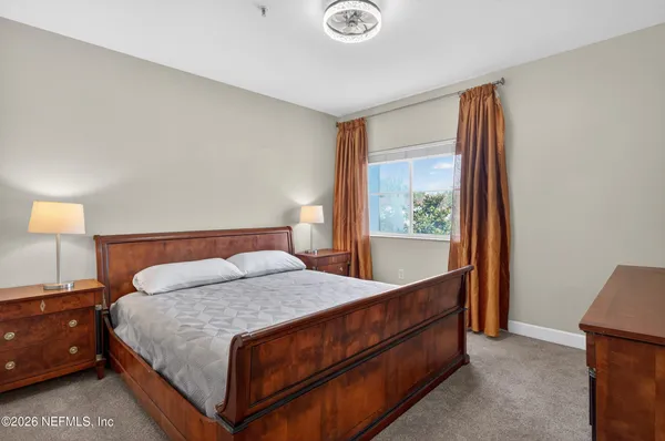 a bedroom with a bed and a large mirror