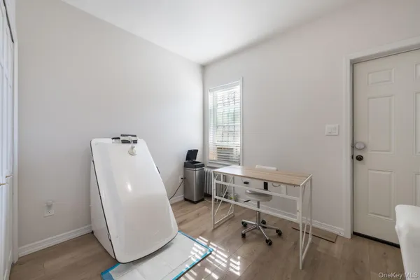 a view of a workspace with furniture and a window