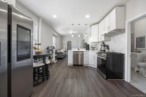 a kitchen with stainless steel appliances kitchen island granite countertop a stove a sink a refrigerator and cabinets