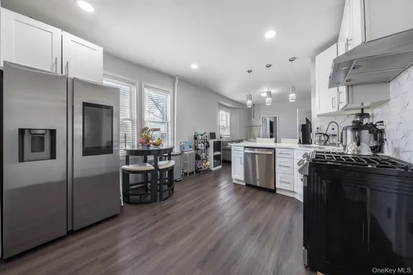 a kitchen with stainless steel appliances a sink a stove top oven a counter space and cabinets