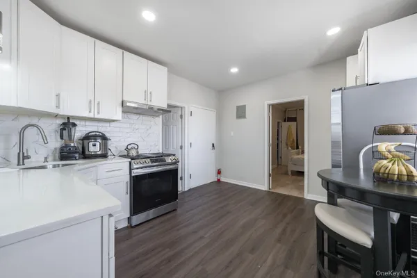 a kitchen with granite countertop a sink cabinets and stainless steel appliances