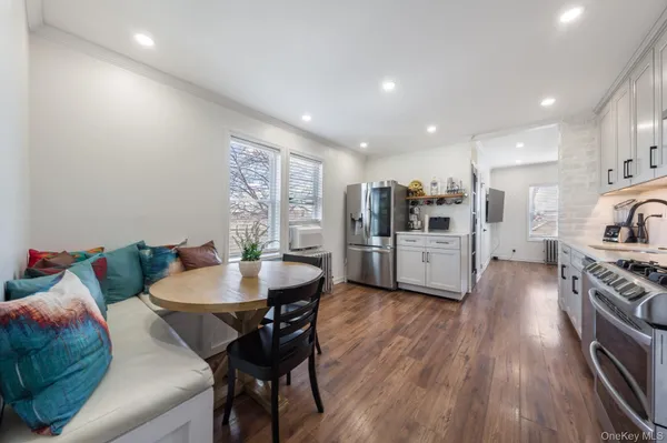 a kitchen with stainless steel appliances kitchen island granite countertop a table chairs stove and refrigerator