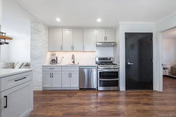 a kitchen with granite countertop white cabinets and stainless steel appliances